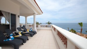 Ein Balkon mit Lounge-Möbeln, gefliestem Boden und Blick auf das Meer.