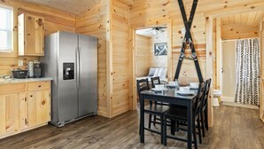 A wooden cabin interior with a kitchen, dining area, and a ski rack. - Linville Gorge 2 Bd 1 Bth Mountain Getaway! (Newland)