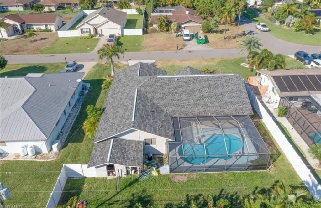 Un quartier résidentiel avec des maisons, une piscine et des panneaux solaires.