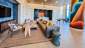 Een moderne woonkamer met een bank, stoelen, een salontafel en een televisie.