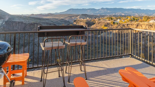 A balcony with a grill, two chairs, and a table. - Best View Ever #17 at The Dwellings (La Verkin)
