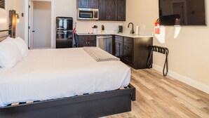 A bedroom with a bed, a kitchen with a microwave, and a TV. - Best View Ever #17 at The Dwellings (La Verkin)