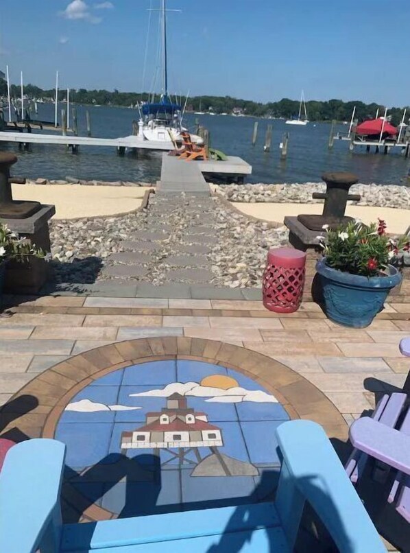A marina with boats, a tiled pathway, and outdoor seating.