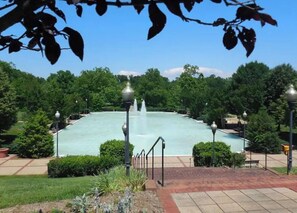 A large rectangular pool with a central fountain, surrounded by well-maintained greenery and paved walkways.