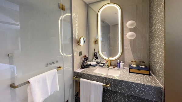 A modern bathroom with a large mirror, a sink, and a towel rack. - voco Nanjing Garden Expo by IHG (Nanjing)