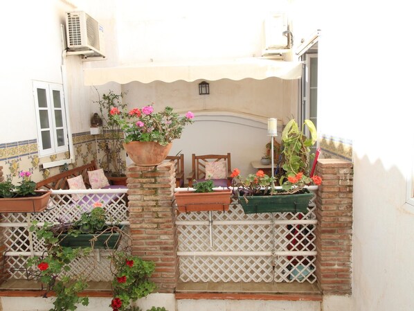 A courtyard with potted plants, a white lattice fence, and a brick wall. - 2 bedrooms with terrace Alamos by Del Parque Flats (Malaga)