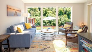 A modern living room with a sofa, chairs, a coffee table, and a bookshelf.