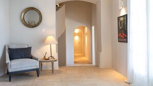 A room with a chair, a lamp, a framed picture, and a doorway leading to another room. - Golfvilla Riviera - luxury villa in the Golfe de Saint Tropez (Grimaud)