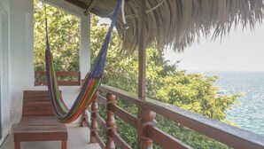 A wooden bench, a hammock, and a railing overlooking a body of water. - Seven Blue House Village & Lodge (Bacalar)