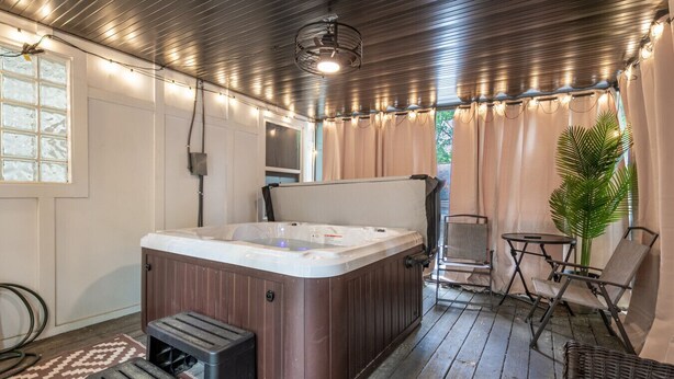 A hot tub in a covered outdoor area with a ceiling fan, a chair, and a potted plant. - Top Level- Atlanta MBS Apartment w/ Private Hot tub (Atlanta)