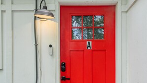 A red door with a small window and a number 'A' sign, a light fixture, and a doormat. - Top Level- Atlanta MBS Apartment w/ Private Hot tub (Atlanta)