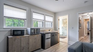 A modern kitchen with a built-in microwave, toaster, and refrigerator, wooden cabinetry, and large windows with blinds. - Top Level- Atlanta MBS Apartment w/ Private Hot tub (Atlanta)