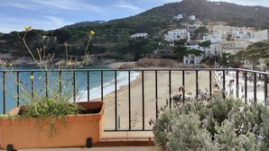 Une vue côtière avec une plage, une montagne en arrière-plan et un ensemble de bâtiments.