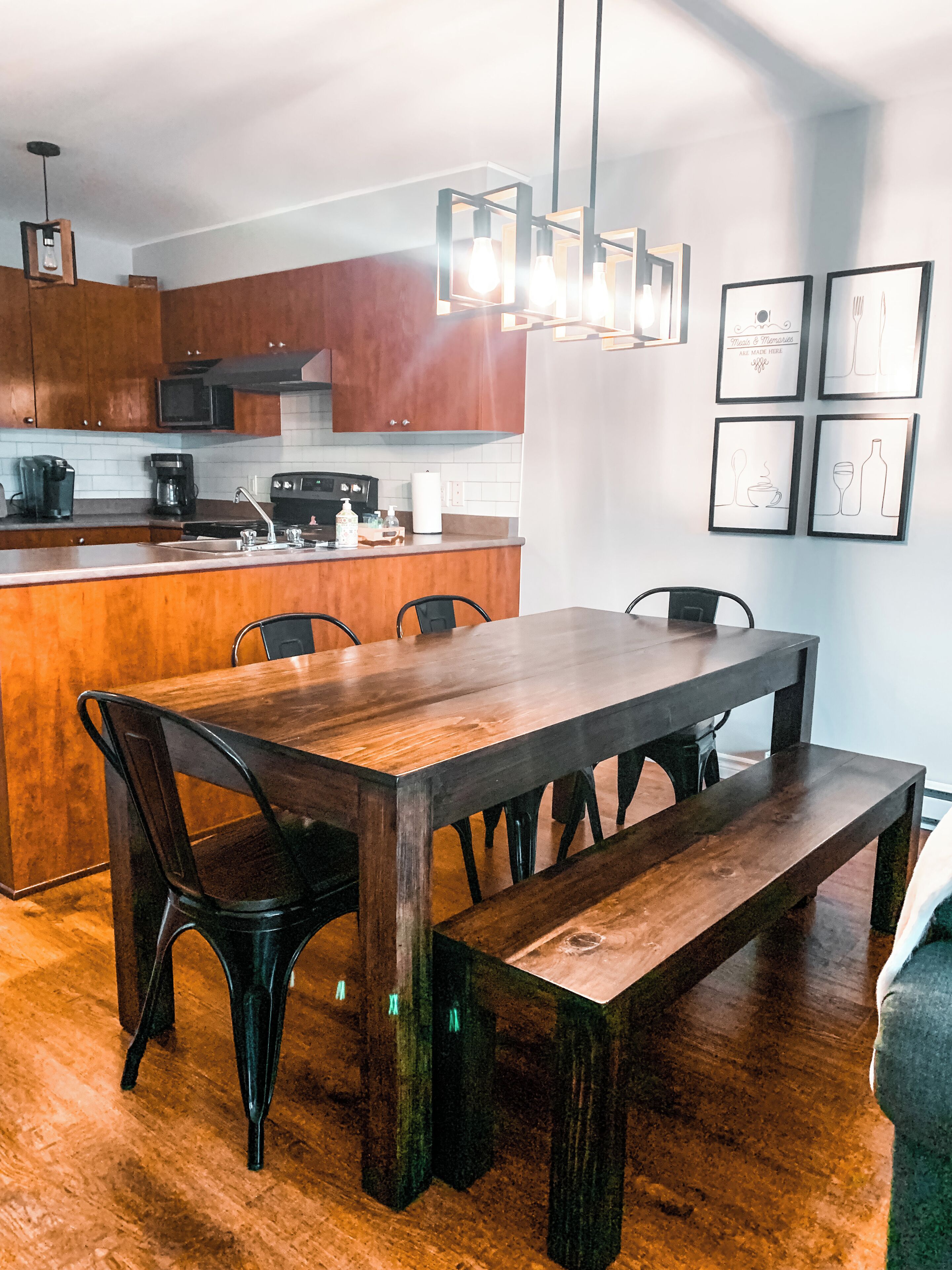 A modern kitchen with wooden cabinets, a built-in island, and a dining area with a large wooden table and chairs.