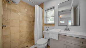 Un baño con ducha, inodoro y lavabo.