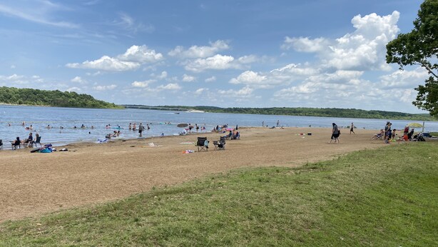 Een strand met mensen die zwemmen en ontspannen.