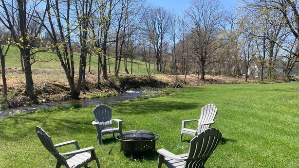 A grassy outdoor area with Adirondack chairs and a fire pit. - Wineries, Hiking, skiing  and fishing minutes from house (Saylorsburg)