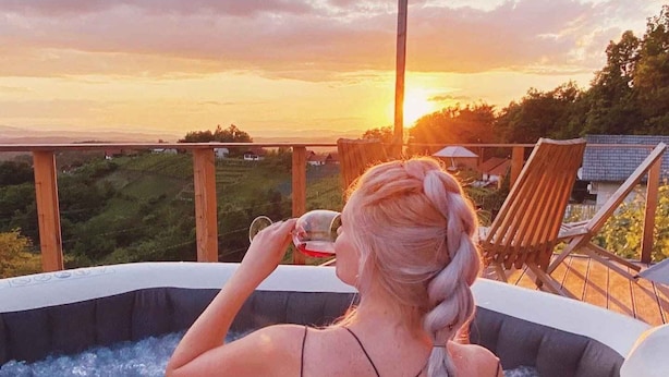 Une personne dans un bain à remous, avec une vue sur le coucher de soleil.