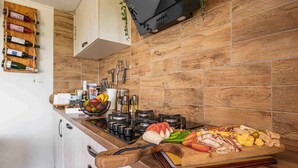 Une cuisine avec un plan de travail en bois, une cuisinière à gaz et une variété d’aliments disposés sur le comptoir.
