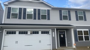 A two-story house with a garage, a front door with a sign, and a mailbox. - Ryan Home (Columbus)