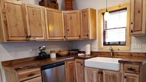 A kitchen with wooden cabinets, a stainless steel dishwasher, and a window with blinds. - 2 STORY ADIRONDACK LOG CABIN-SKI ! SKI! SKI! (Lake George)