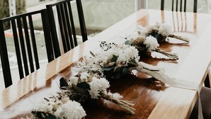 A dining table with floral centerpieces and a chandelier. - The Cutting Estate Mount Panorama (Mount Panorama)