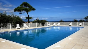 A rectangular swimming pool with a tiled deck, surrounded by white lounge chairs and a white fence. - Nice apartment in villa for 6 guests with pool, A/C, WIFI, TV, terrace and pets allowed (Borgo)