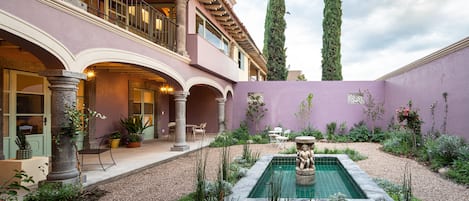 Un patio con piscina, asientos y una estatua.