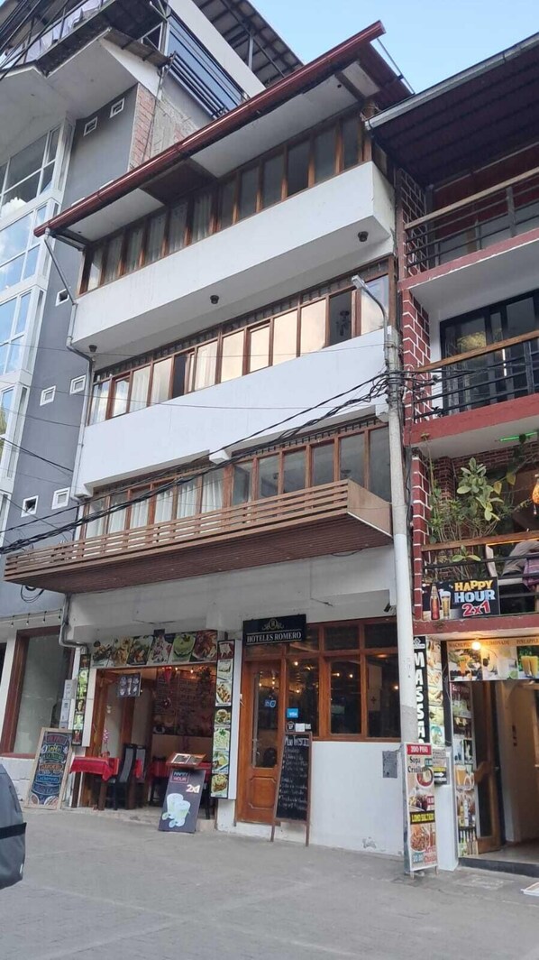 Un hotel con restaurante en la planta baja y un cartel que dice 'HOTEL ROMERO'.