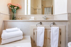 Bathtub, hair dryer, towels, shampoo