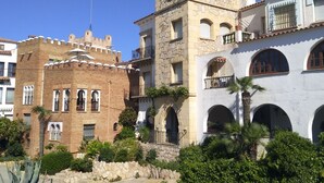 Ein historisches Gebäude mit einer Stein-Fassade, Rundbogenfenstern und einem Turm.