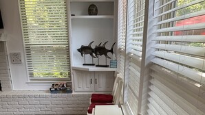 A room with a white brick wall, a white cabinet with two fish sculptures, and a white table with red cushions. - Amazing! ATnT Stadium Rangers New Ball Park, Six Flags, Hurricane Harb Tex Live! (Arlington)
