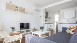 A modern living room with a grey sofa, a TV, and a small table with plants. - B-High quality apartment 3 bedrooms, 2 bathrooms pool Alcalá - Aral (Algaba)