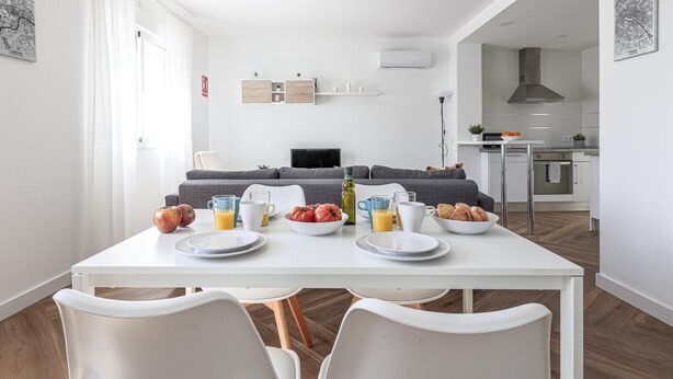 A modern, well-lit living room with a dining area. There is a sofa, a TV, and a kitchen in the background. - B-High quality apartment 3 bedrooms, 2 bathrooms pool Alcalá - Aral (Algaba)