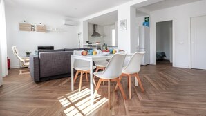 A modern, open-plan living space with a dining area, sofa, and kitchen. - B-High quality apartment 3 bedrooms, 2 bathrooms pool Alcalá - Aral (Algaba)