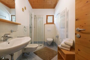 Un bagno con lavandino, servizi igienici, doccia e portasciugamani.