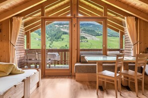 Une cabane en bois avec un balcon, un lit, une table et des chaises.