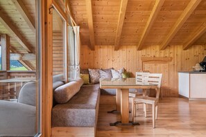 Un interior de madera con sofá, mesa de comedor y sillas.
