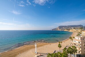 Paesaggio costiero con spiaggia, oceano e edifici.