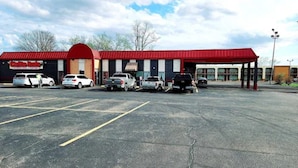 A parking lot with several cars parked in front of a building with a red roof and a sign that reads "Café Auto". - Roadside Inn (Osceola)