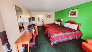 A hotel room with two beds, a desk, a chair, and a mirror.