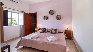 A bedroom with a bed, bedside tables, a window, and a door. - Pet-Friendly Villa 'Casa dos Jotas' with Pool & Wi-Fi (Martinlongo)