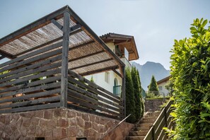 Een stenen gebouw met een houten balkon en een trap die naar een hoger niveau leidt.