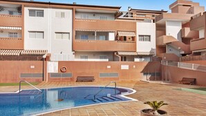 A swimming pool with steps, a lifebuoy, and a potted plant. - Vacation Apartment 'Puertito Guimar' with Shared Terrace, Balcony and Wi-Fi (Guimar)