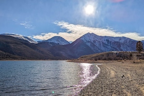 Un lago con montañas al fondo y un cielo despejado.