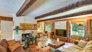 Un salón acogedor con chimenea, muebles de madera y un letrero que dice 'After the Rain antiques'.
