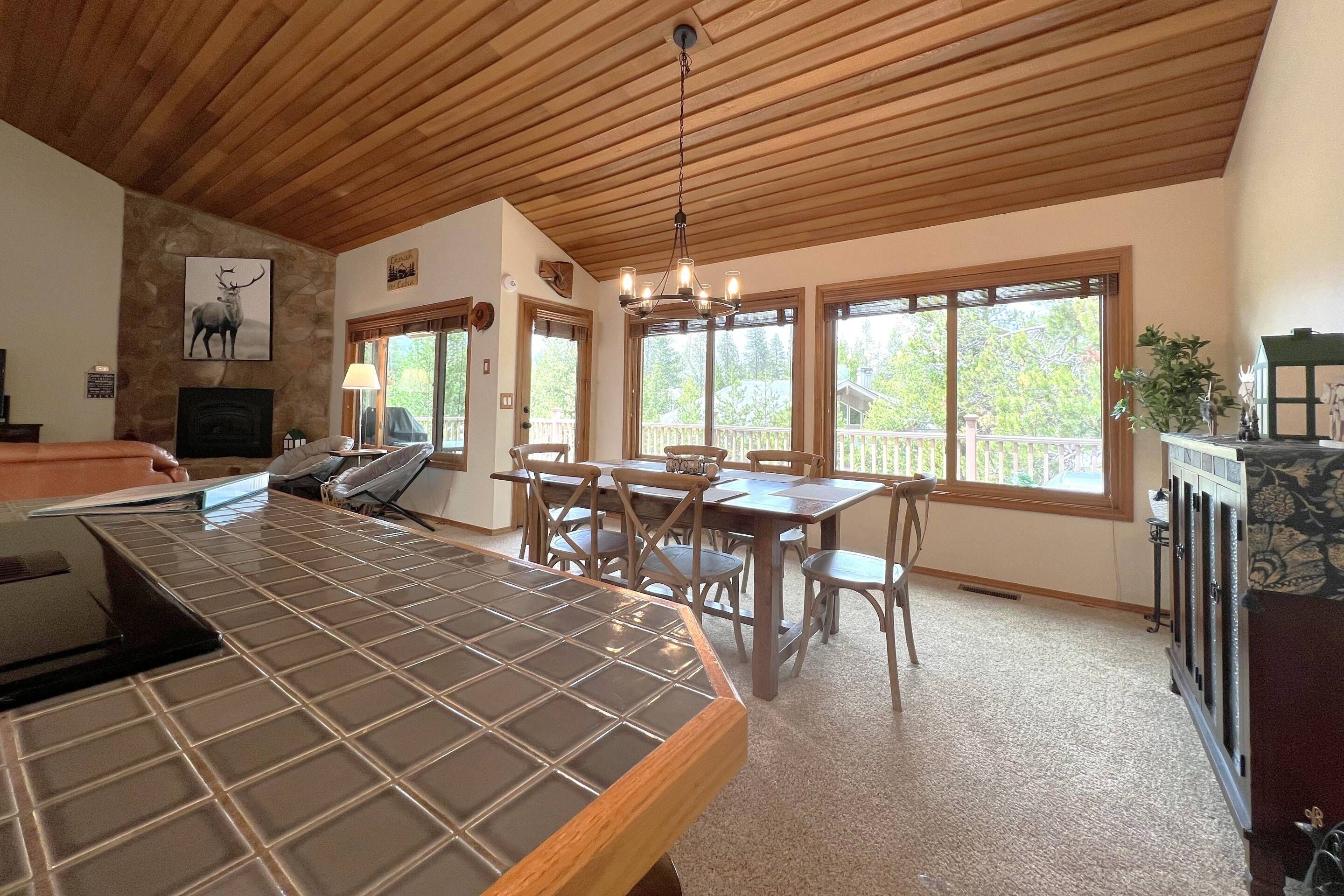 Eine geräumige Küche mit einer großen Kochinsel, Holzbalkendecke und großen Fenstern.