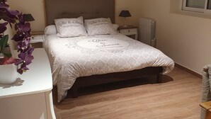 Una camera da letto con un letto, comodini, un termosifone e una finestra.