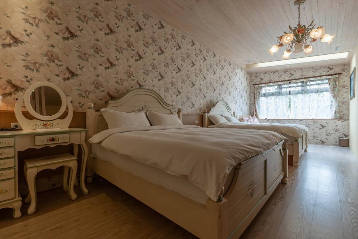Un dormitorio con una cama grande, un aparador con espejo y una ventana con cortinas.