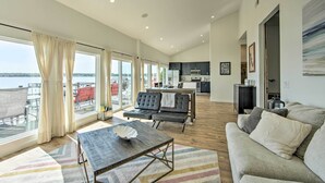 A spacious living area with a large window, a sofa, a coffee table, and a view of the outside.